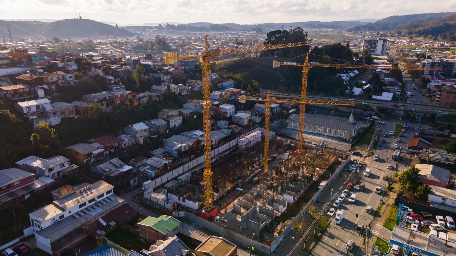Vista aérea de obra urbana con grúas en Concepción
